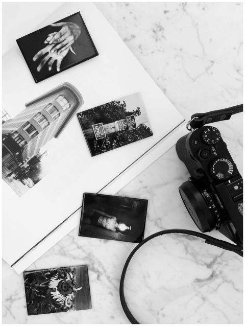 Flat lay of black and white photos with a camera o