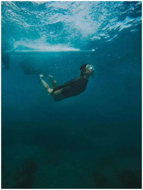 Person snorkeling underwater in the clear ocean ar