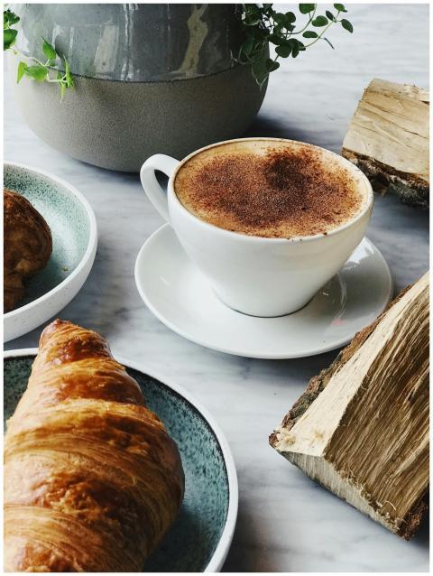 Close-up of a steaming cappuccino with a golden cr