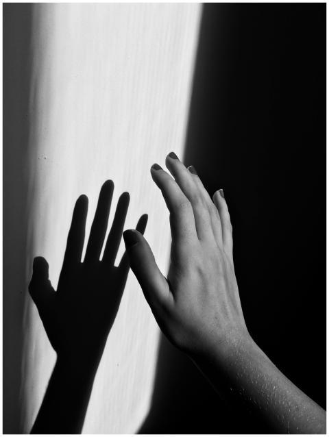 A monochrome photo of a hand casting a shadow on a