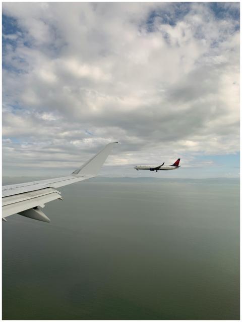 Airplane flying over open water with a clear sky,