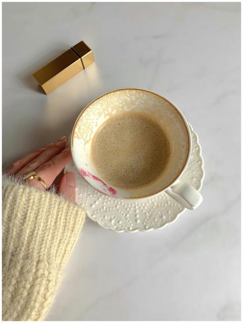 A cozy scene with a ceramic cup of coffee on a whi