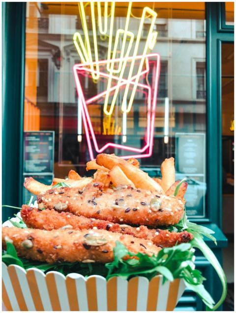 Close-up of crispy chicken strips with fries in a