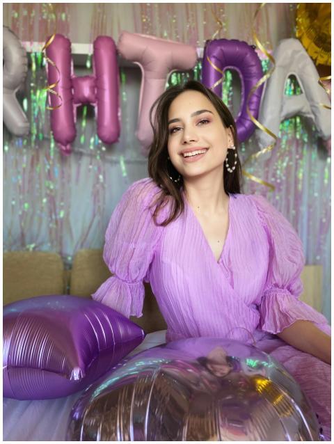 Cheerful woman in a purple dress at a vibrant birt