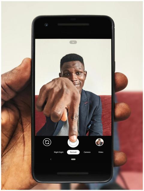 Portrait of a man using a smartphone to take a sel