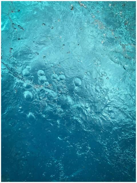 Detailed shot of bubbles in blue water creating a