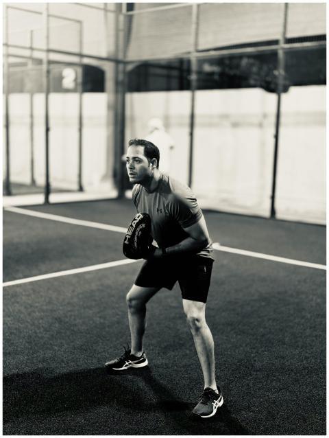 Focused male player on a padel court, ready for ac