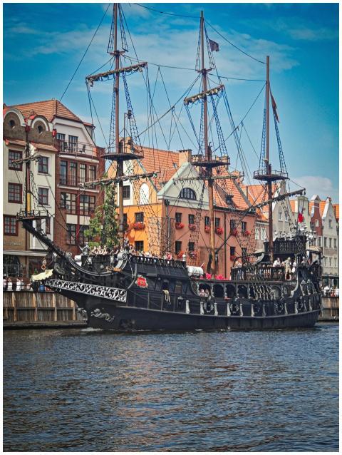 A stunning historical pirate ship docked against c