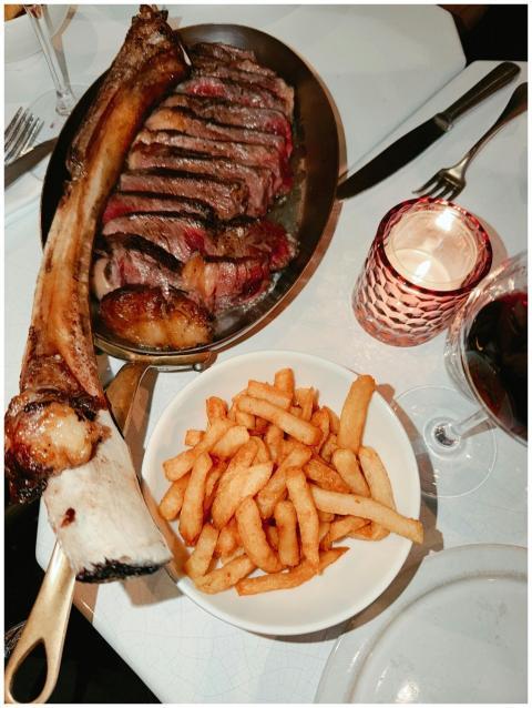 Sliced rib steak served with fries and red wine fo