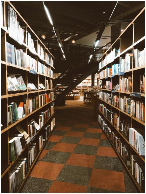 Warmly lit library aisle filled with a vast collec
