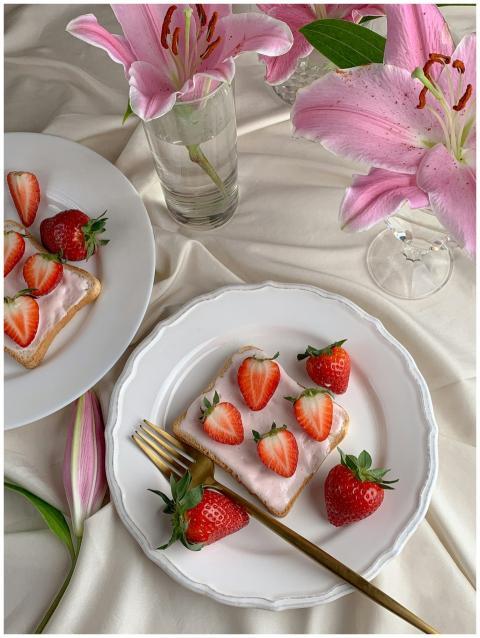 Elegant flat lay of strawberry toasts with pink li