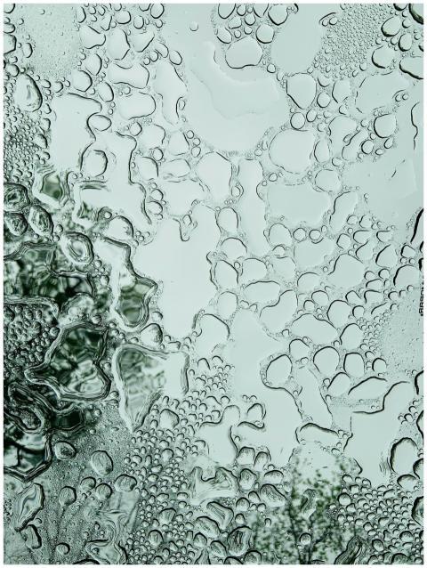 Close-up of water drops on glass creating an abstr