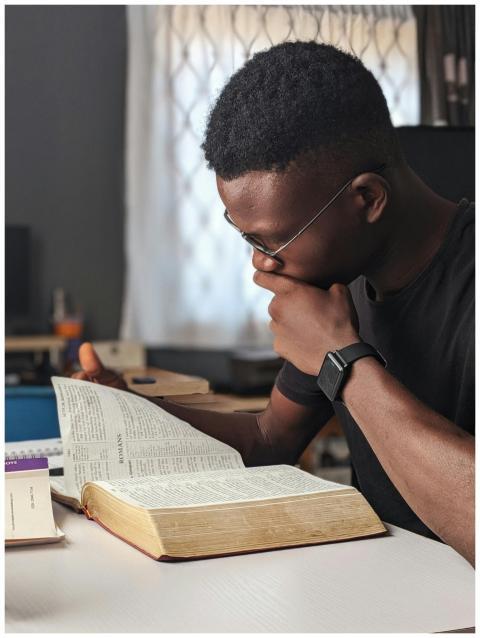 Young man deeply engaged in reading a book at home