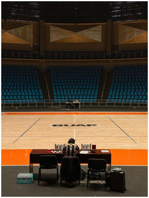 A lone official at a table on an empty basketball