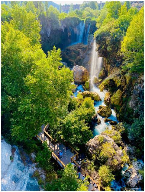 A breathtaking waterfall cascades through a lush g