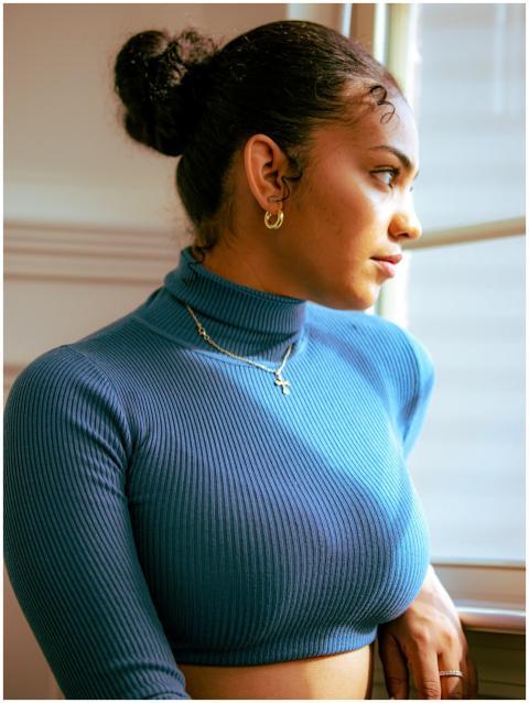 Portrait of a woman in a blue turtleneck gazing ou