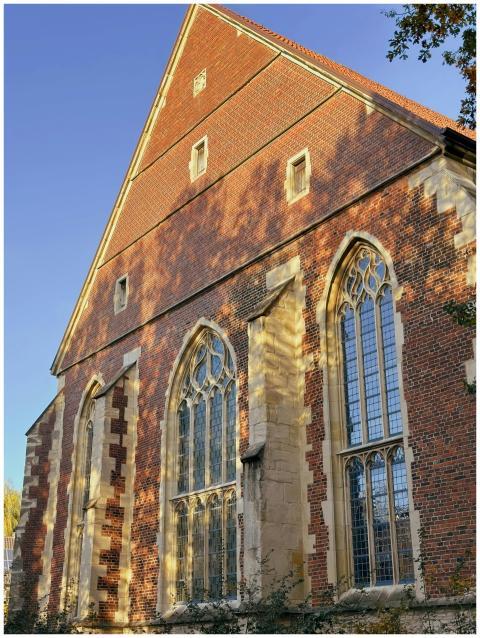A brick Gothic church facade with arched windows i