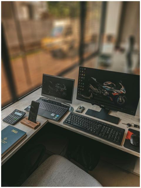 A modern workspace featuring dual monitors, laptop