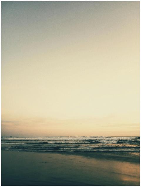 A tranquil beach scene at sunset with gentle waves