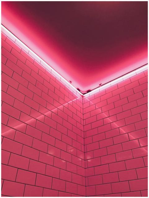 Aesthetic neon-lit pink tiled corner creating a mo