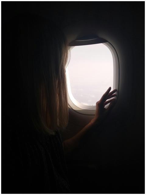 A woman silhouetted against the bright sky, gazing