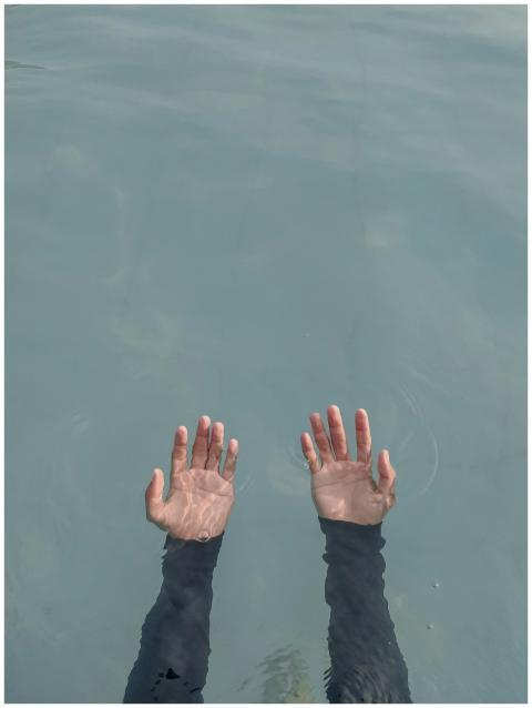 Serene image of hands submerged in water, capturin