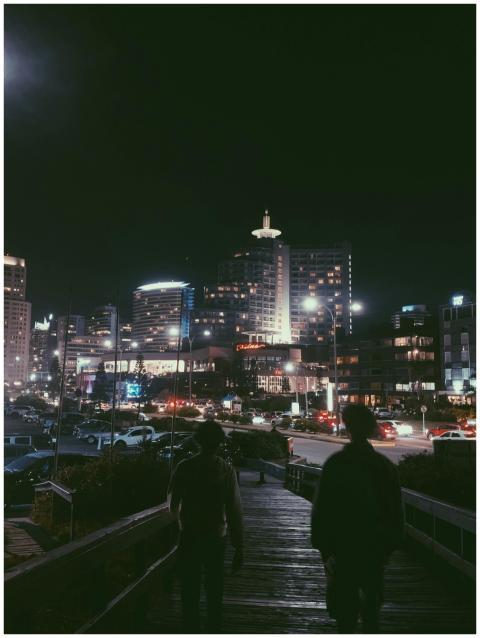 A bustling city street at night with illuminated b