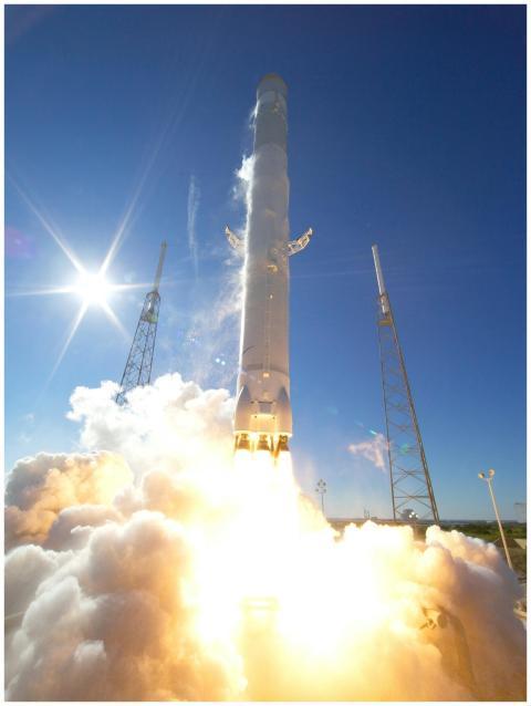 A powerful rocket takes off into a clear blue sky,