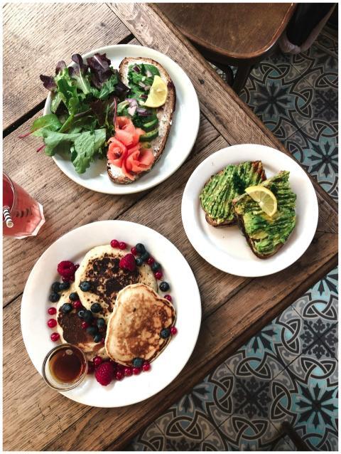 Delicious brunch with avocado toast, pancakes, and