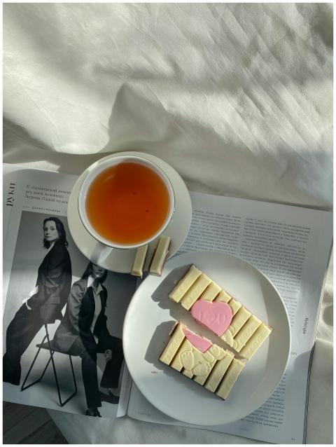 A relaxing setup with tea and sweets on a bed, per