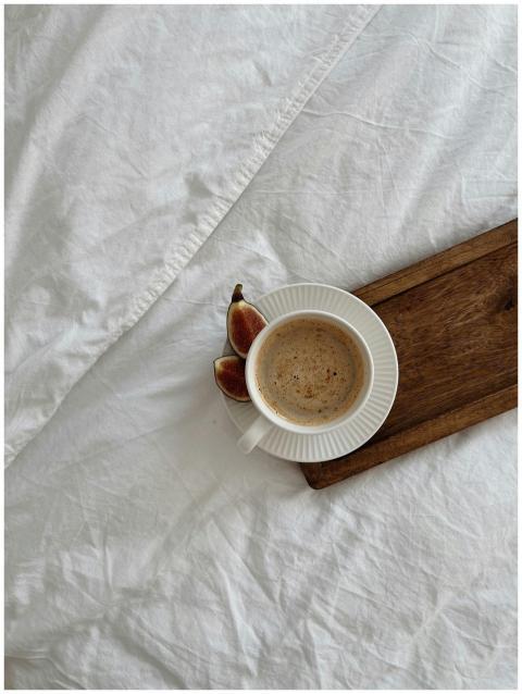 A cozy setup featuring a coffee cup with figs on a