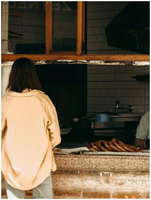 Woman buying fresh pastries from a street bakery w