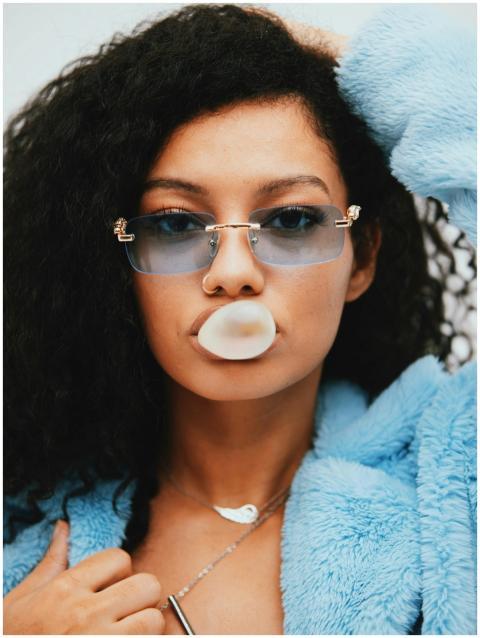 Trendy young woman wearing blue sunglasses with a