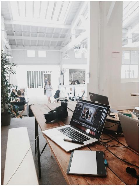 A bright, modern workspace featuring laptops, a ca
