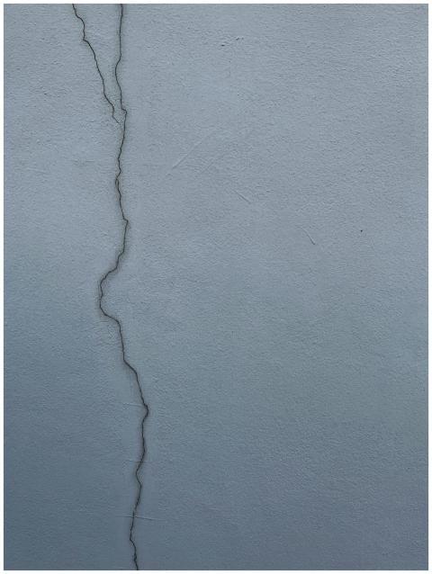 Close-up of a cracked cement wall displaying textu