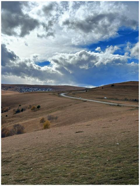 A scenic view of rolling hills under a dramatic sk