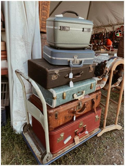 A collection of vintage suitcases stacked on a car