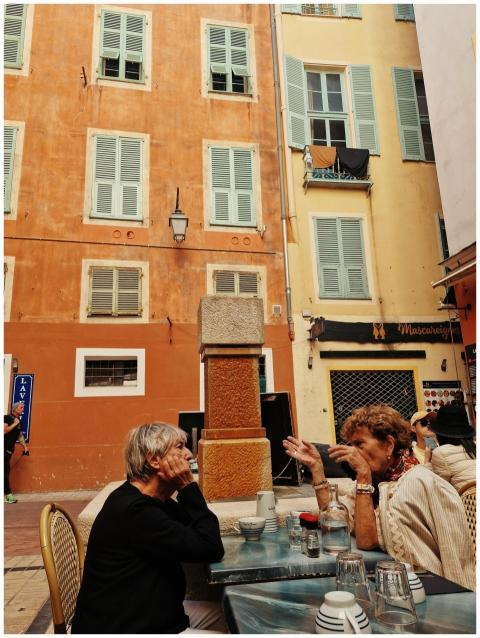 Two women enjoy conversation at a quaint outdoor c
