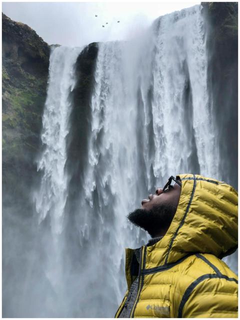 A man in a yellow jacket appreciating a powerful w