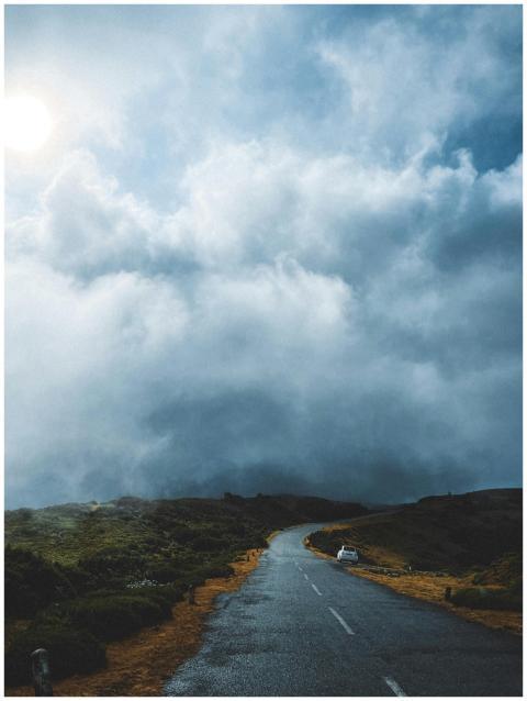 Misty road on Madeira Island under dramatic clouds
