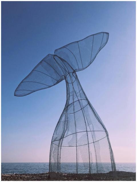 A breathtaking metal whale tail sculpture against