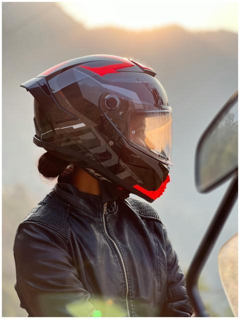 A stylish motorcyclist in a helmet enjoys a serene