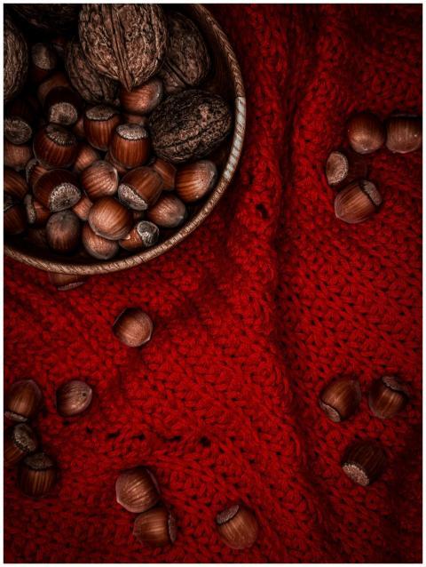 Close-up of assorted nuts on a red knit fabric, em