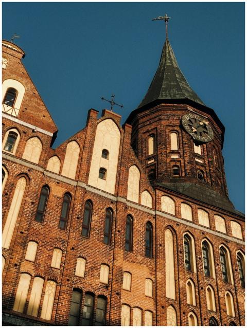 Gothic-style brick building with clock tower under