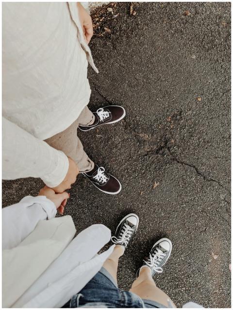 Top view of a couple casually holding hands on a p