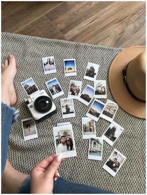 Flat lay of instant photos and a camera on a mat,