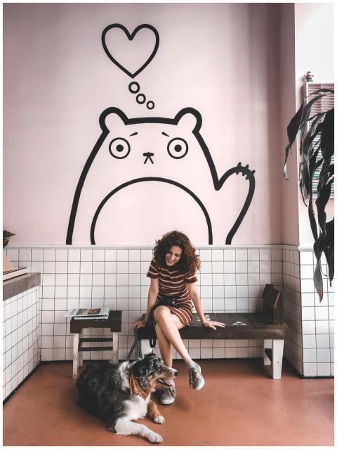 Smiling woman with her dog inside a stylish cafe w