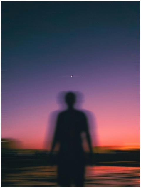 Silhouette of a person against a vibrant dusk sky