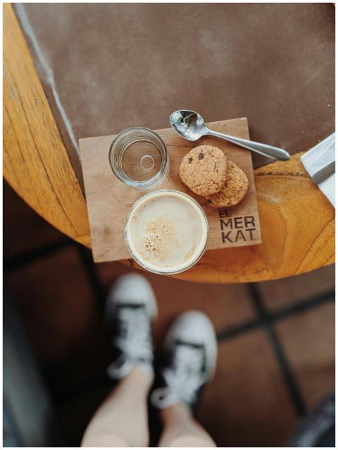 Top view of coffee, cookies, and sneakers at Bali'