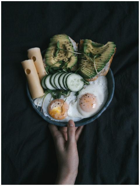 Delicious avocado toast with eggs, cheese, and veg